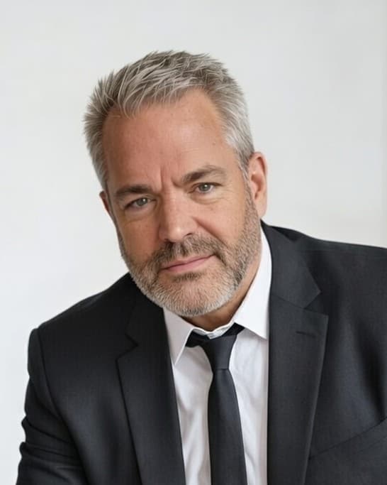 Headshot of comedian Mike James in a dark suit and tie